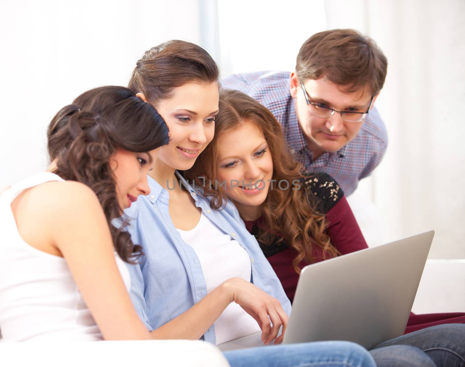 four students with notebook on  sofa, at campus