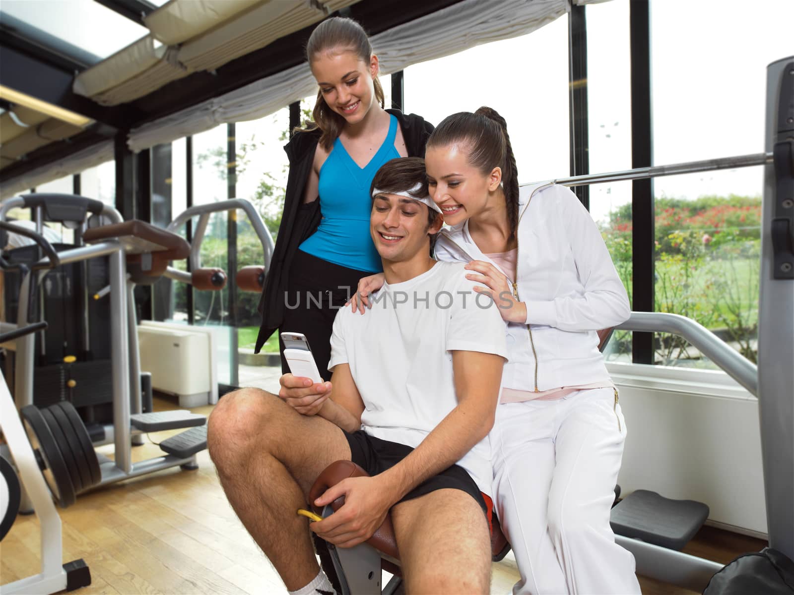 beautiful smiling sports people read sms on phone in big sports hall