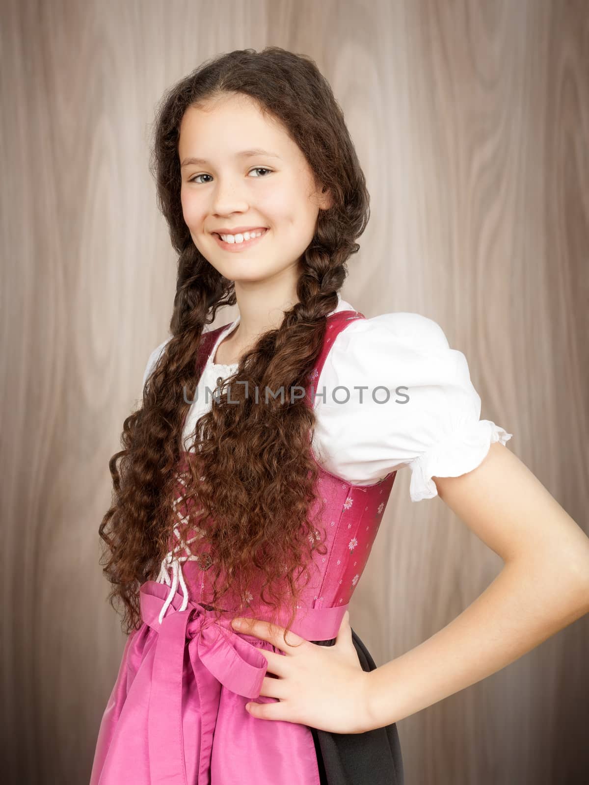 A sweet traditional bavarian girl in front of a wooden background