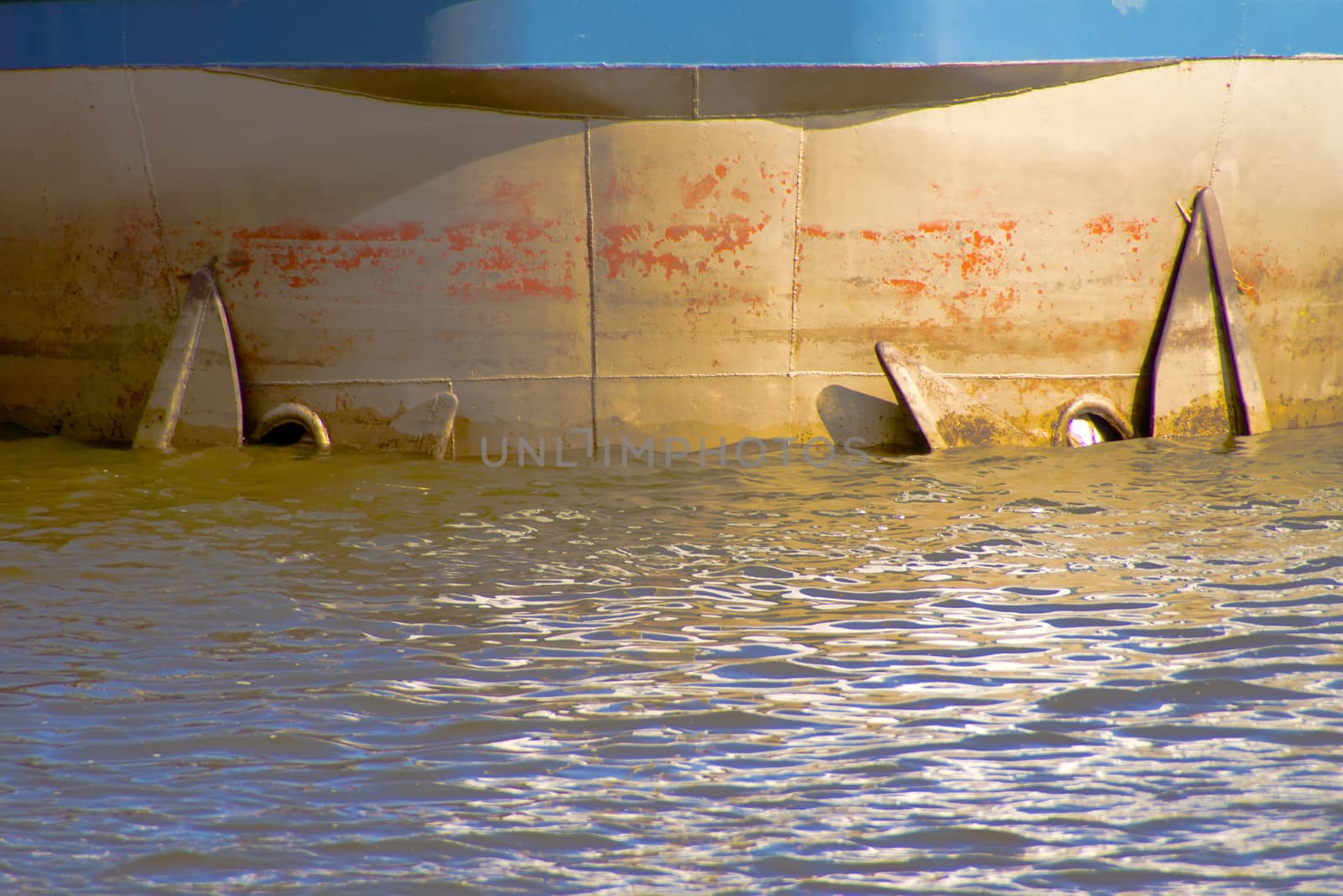 The prow of a tanker ship with anchor in water.