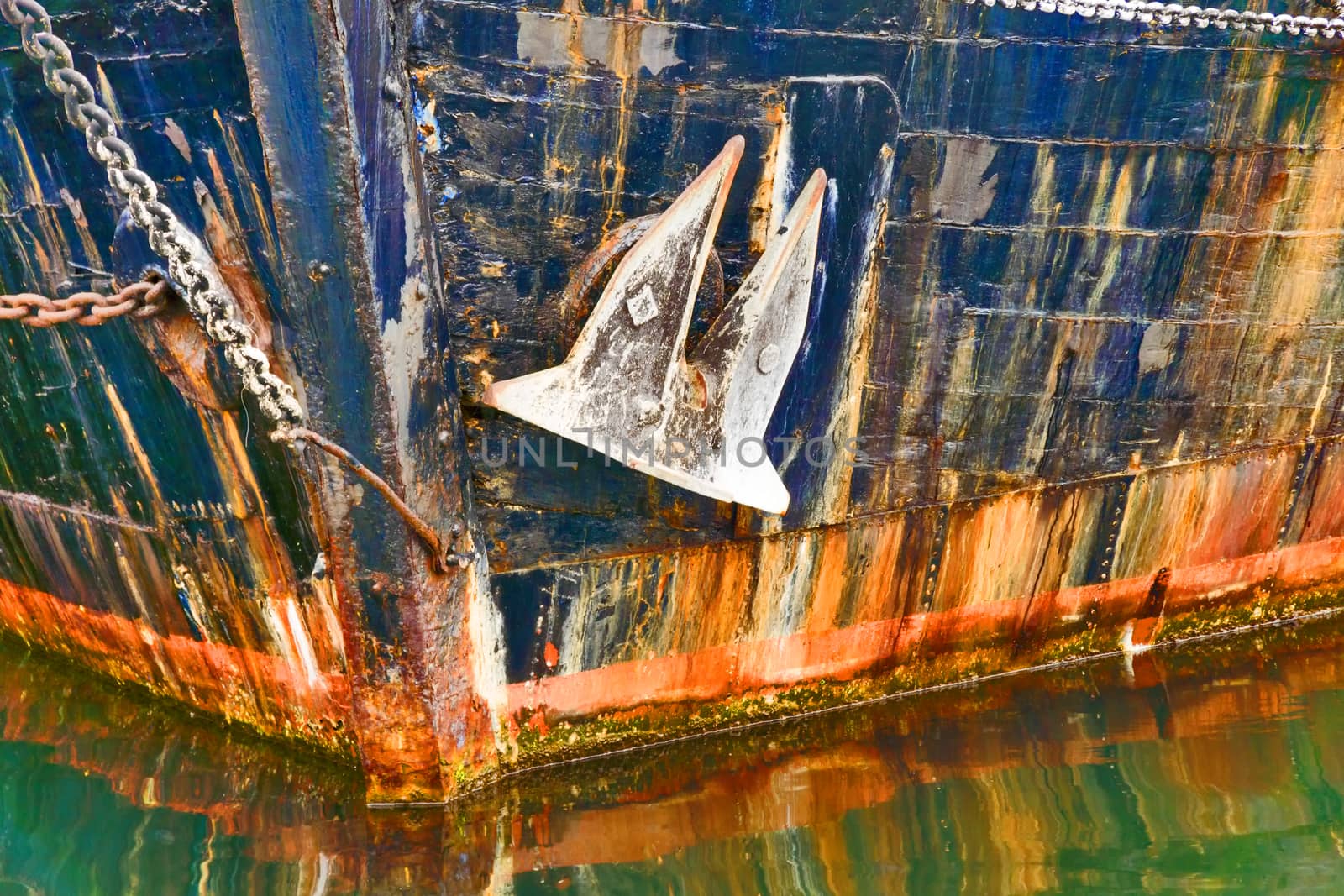 The prow of an old ship with anchor in water.