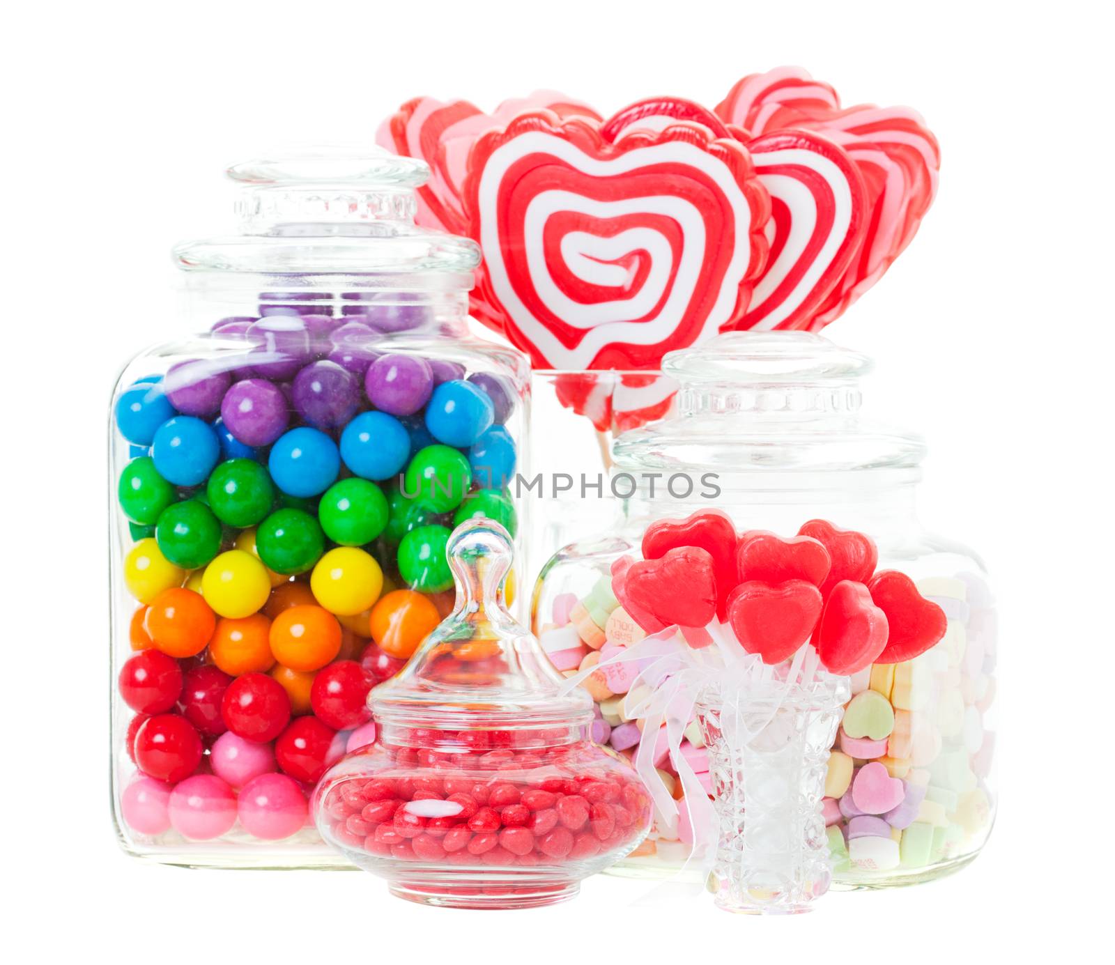 A display of various candies in glass containers.  Shot on white background.