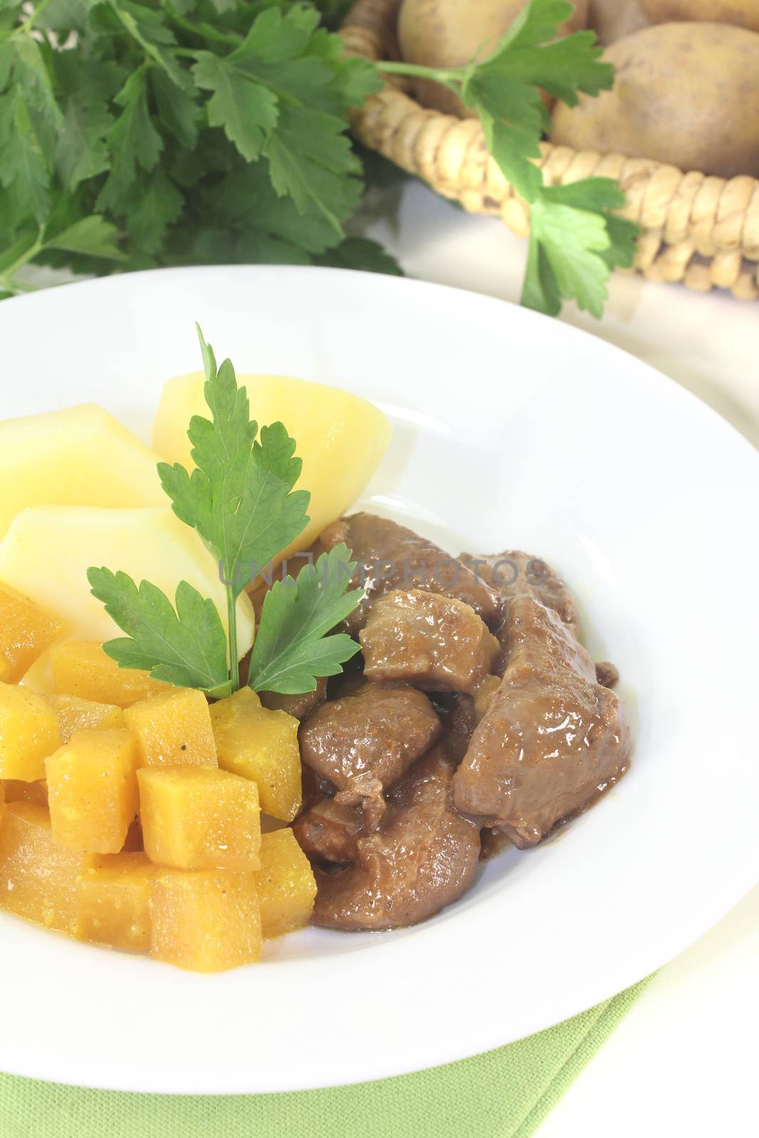 Venison goulash with turnip and parsley on a light background