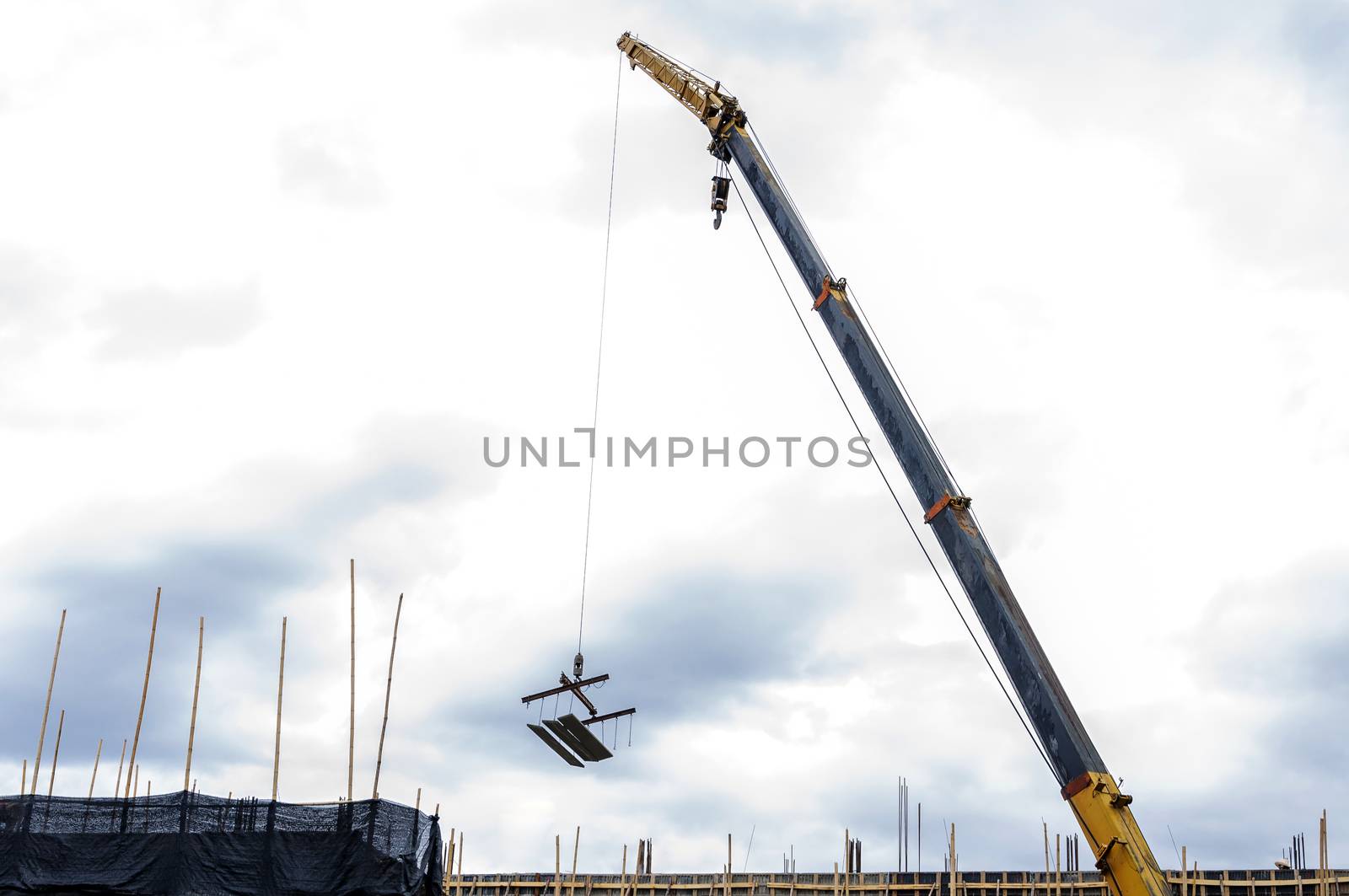 Crane hoist concrete plate at construction site