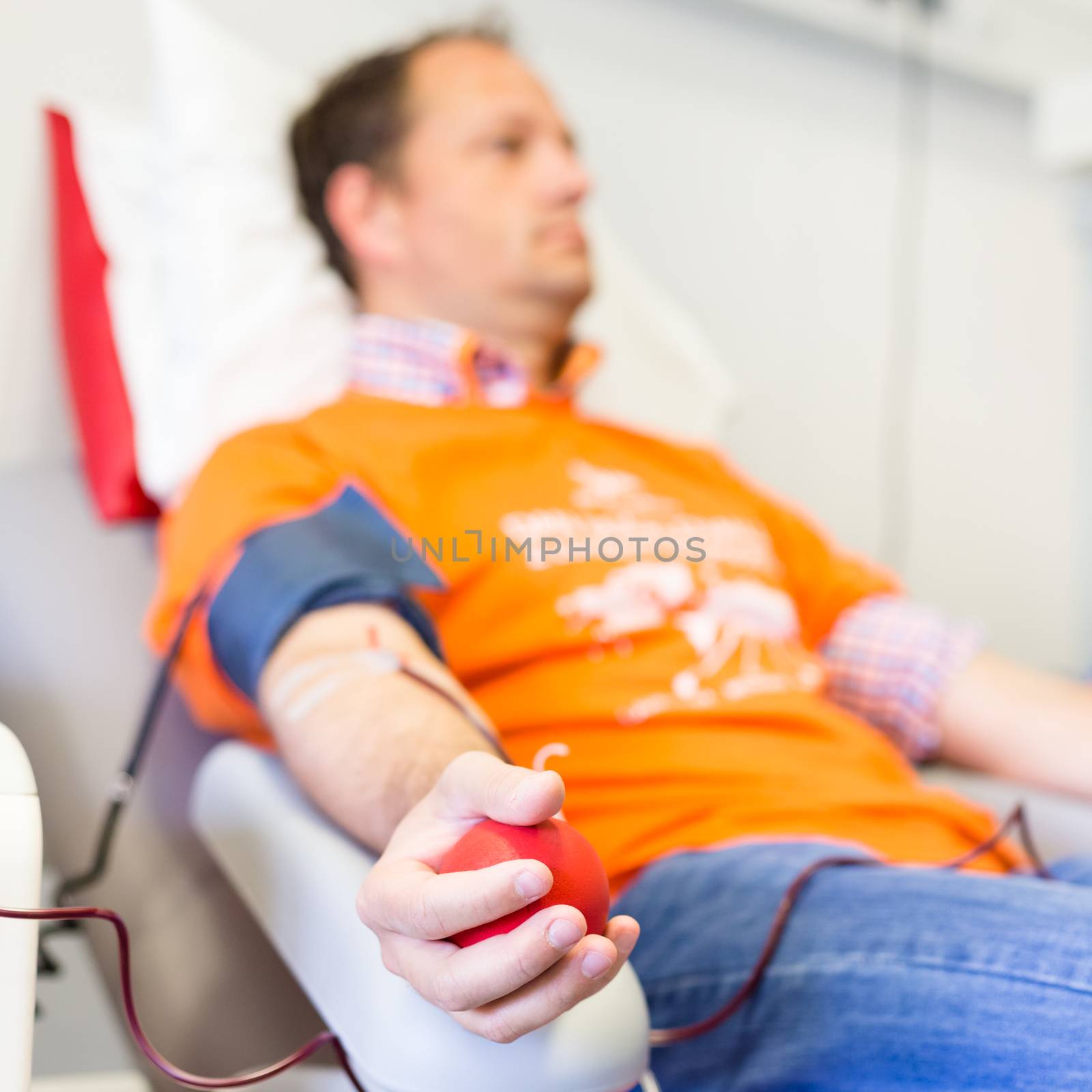 Blood donor at donation with a bouncy ball holding in hand.
