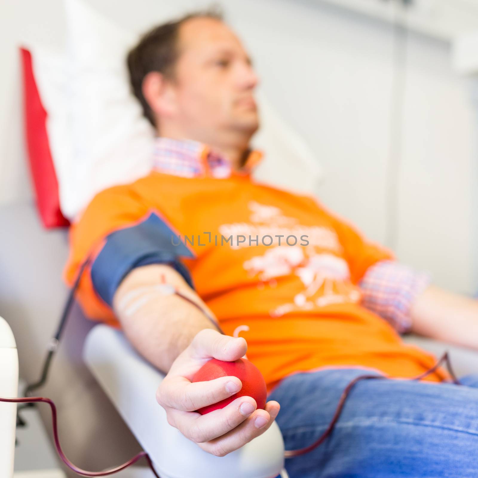 Blood donor at donation with a bouncy ball holding in hand.