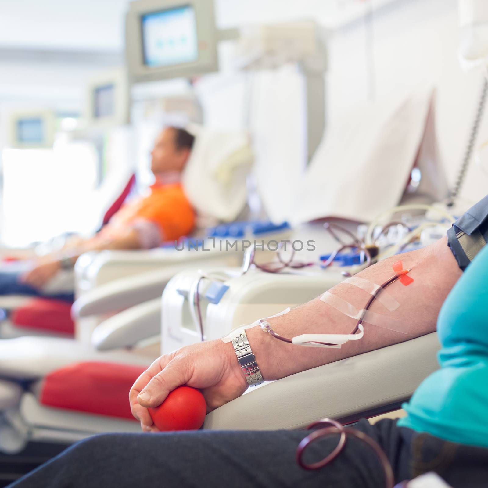 Blood donor at donation with a bouncy ball holding in hand.