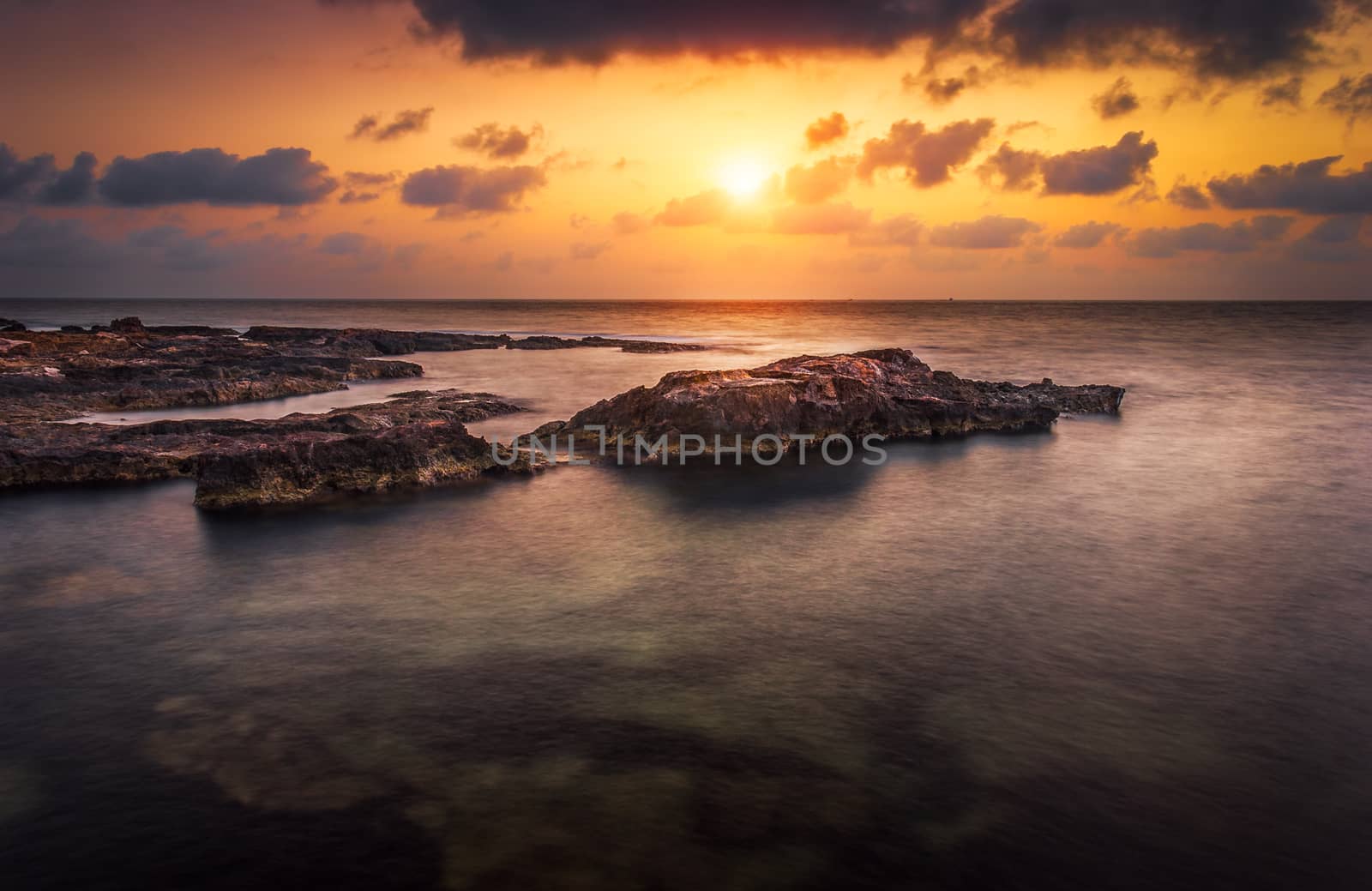 sunset over the sea and rocky coast