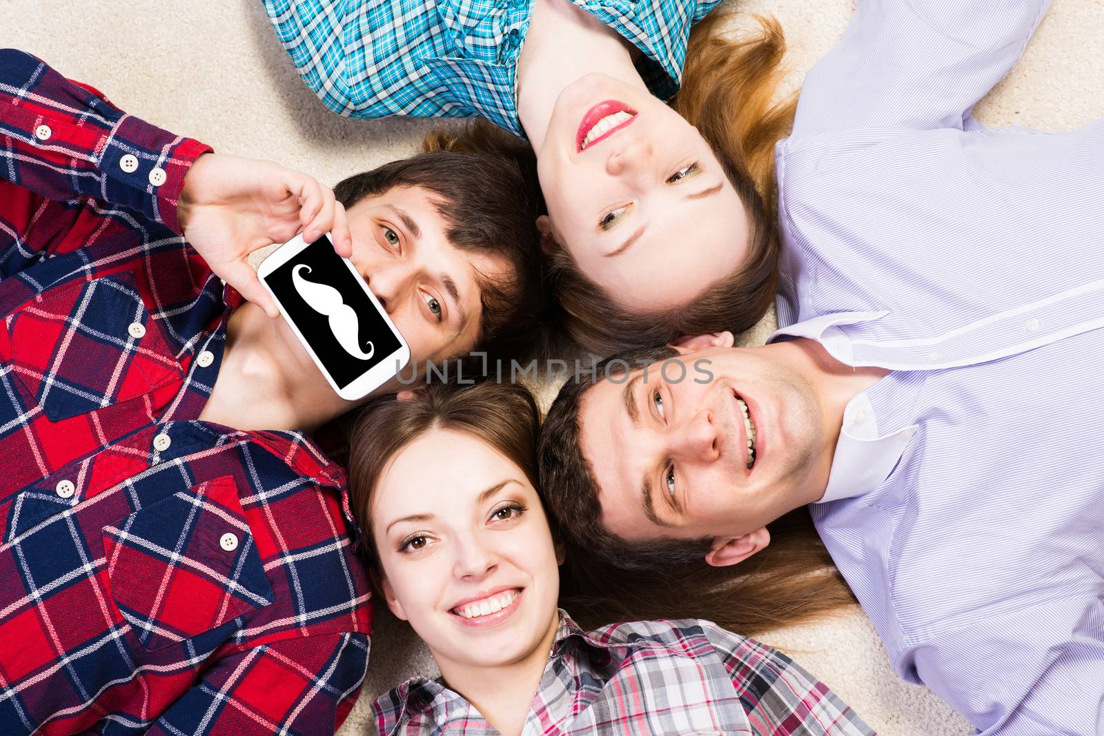 four young people are together, the young man pressed his lips to the phone