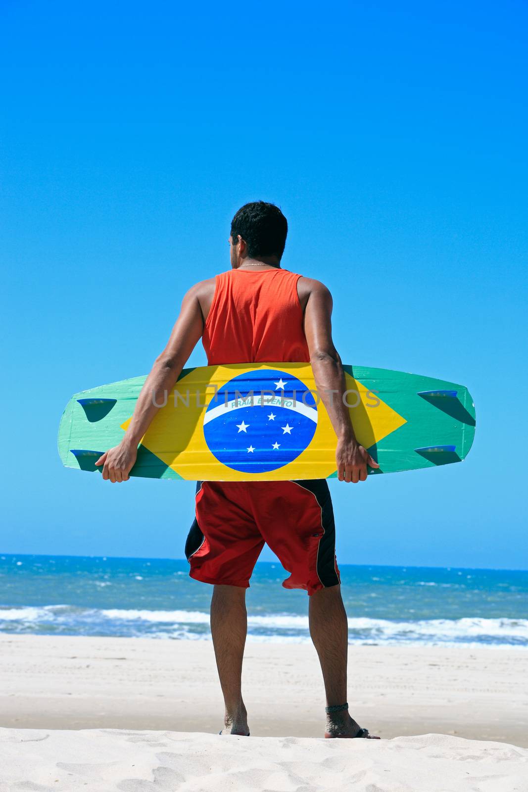 Kite surfer with the Brazilian flag painted on the board with "praia e vento" (beach and wind) instead of "ordem e progresso" in prainha beach near fortaleza