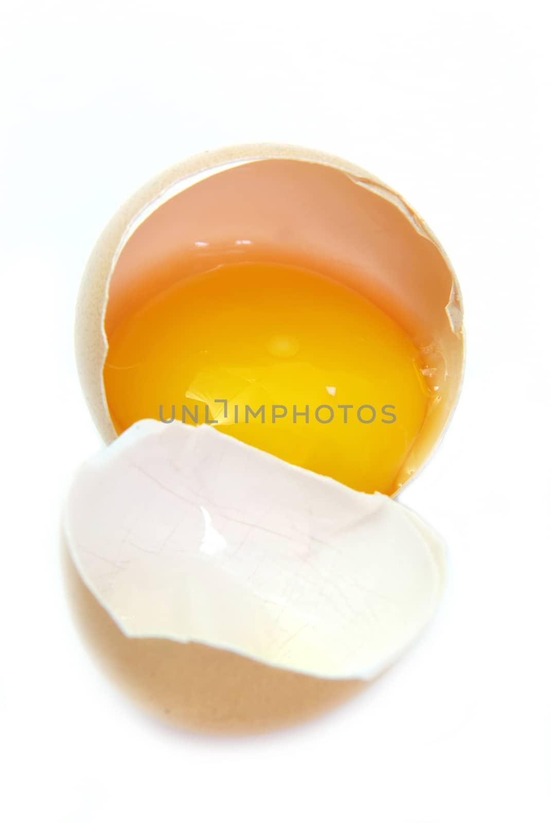 Close up image of a broken egg over white