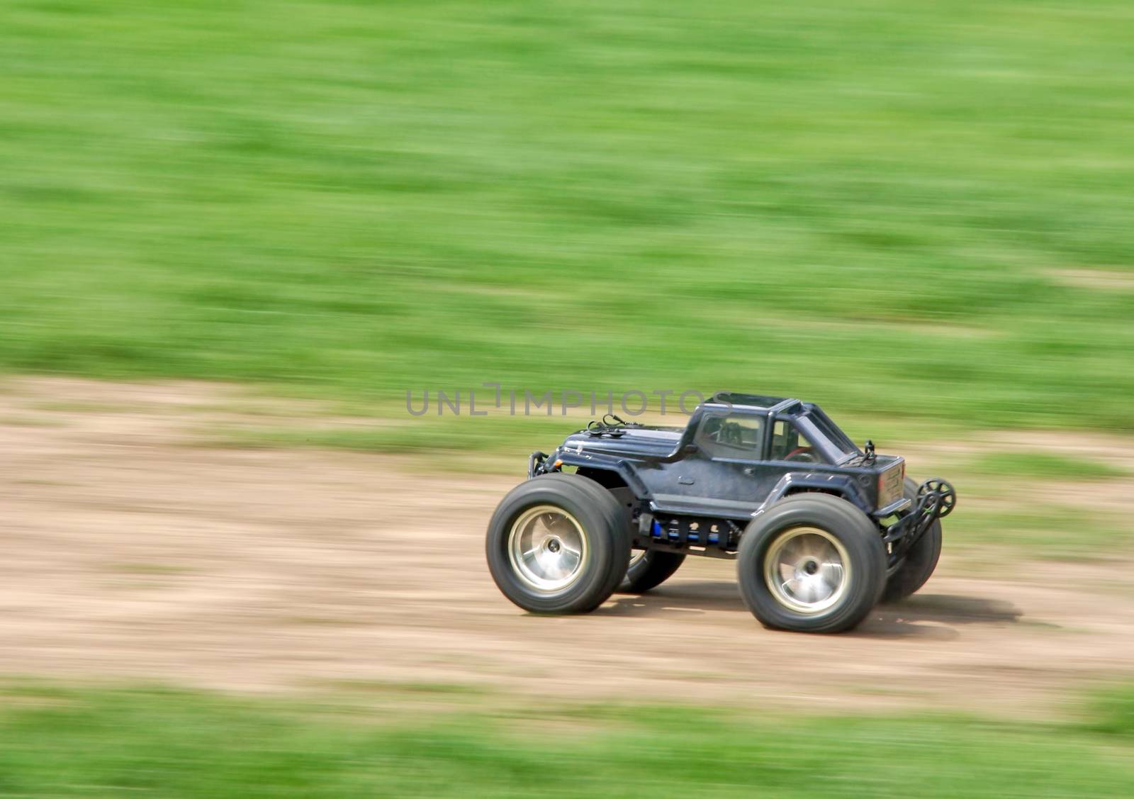 Speeding radio controlled car on the grass.