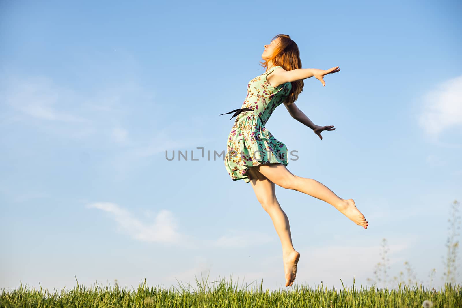 Happy Young Woman Jumping over blue sky