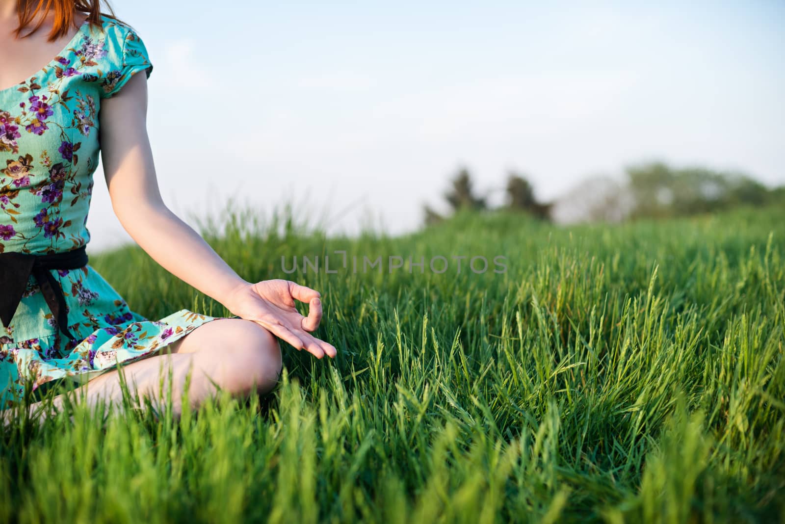 Pretty woman meditate sitting on the grass