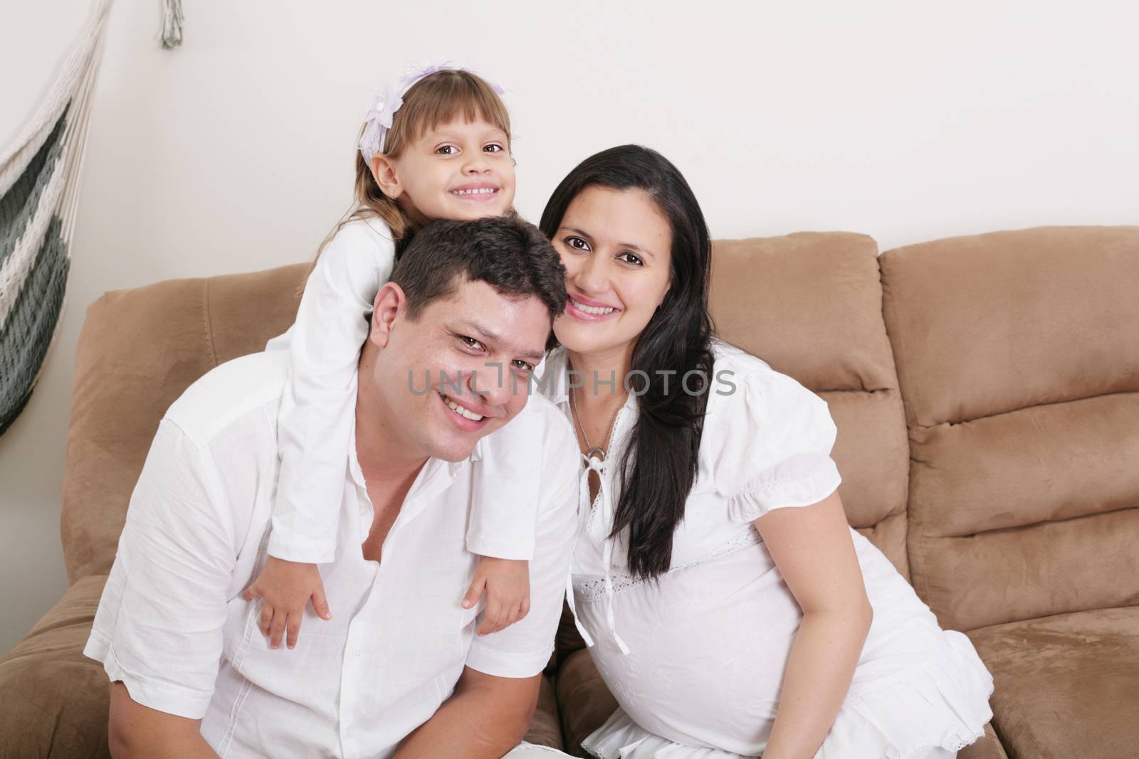 Embracing a happy family with child at home and expectant mother by dacasdo
