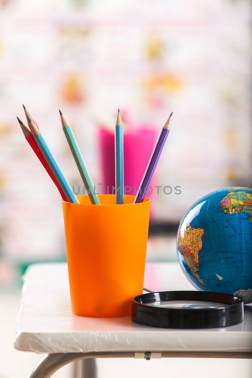 Pencils, globe and book on table 