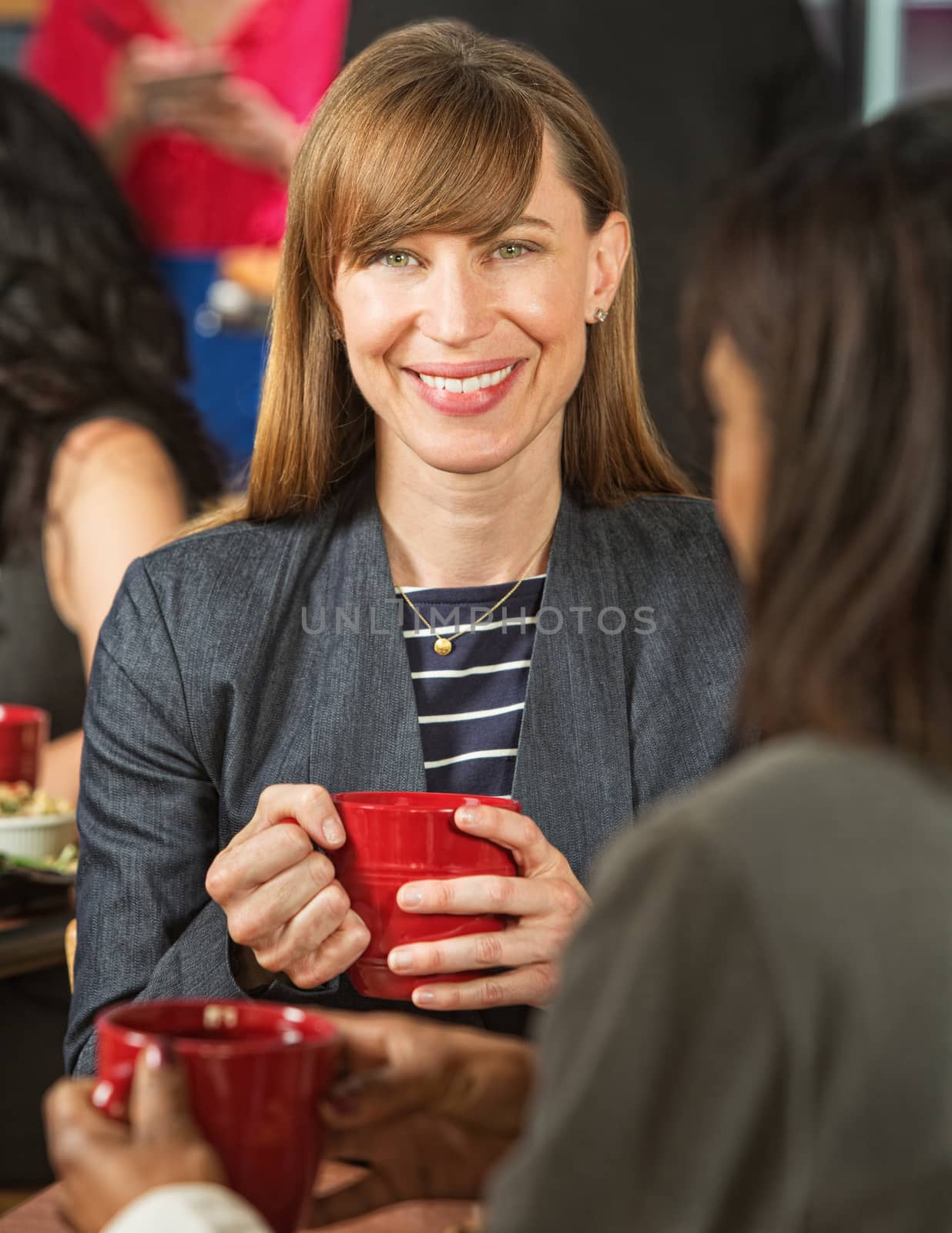 Beautiful smiling businesswoman in coffee house with cup