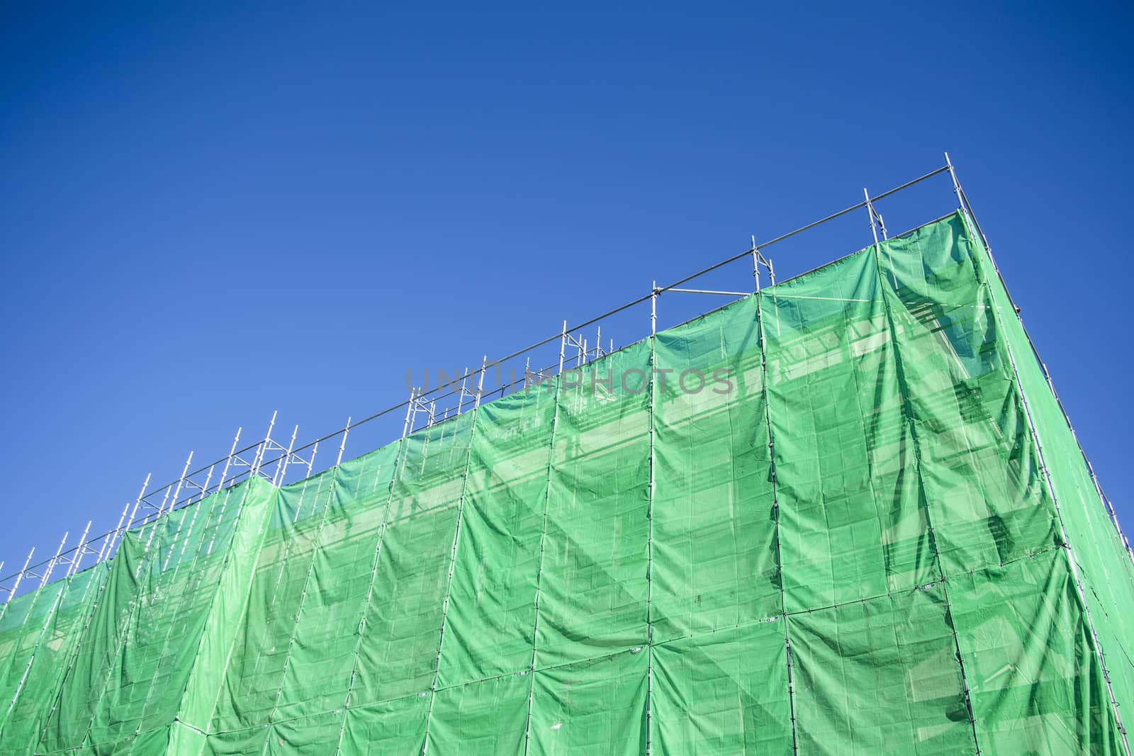 Green cloth cover on building construction site by 2nix