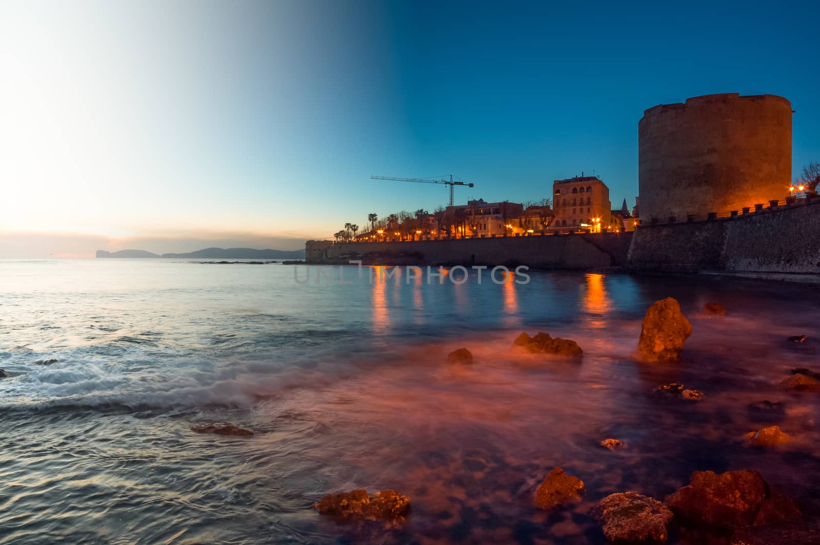 Beautiful landscape of the coast of sardinia, city of alghero, made with two exposures, the first one at sunset and the second one at night