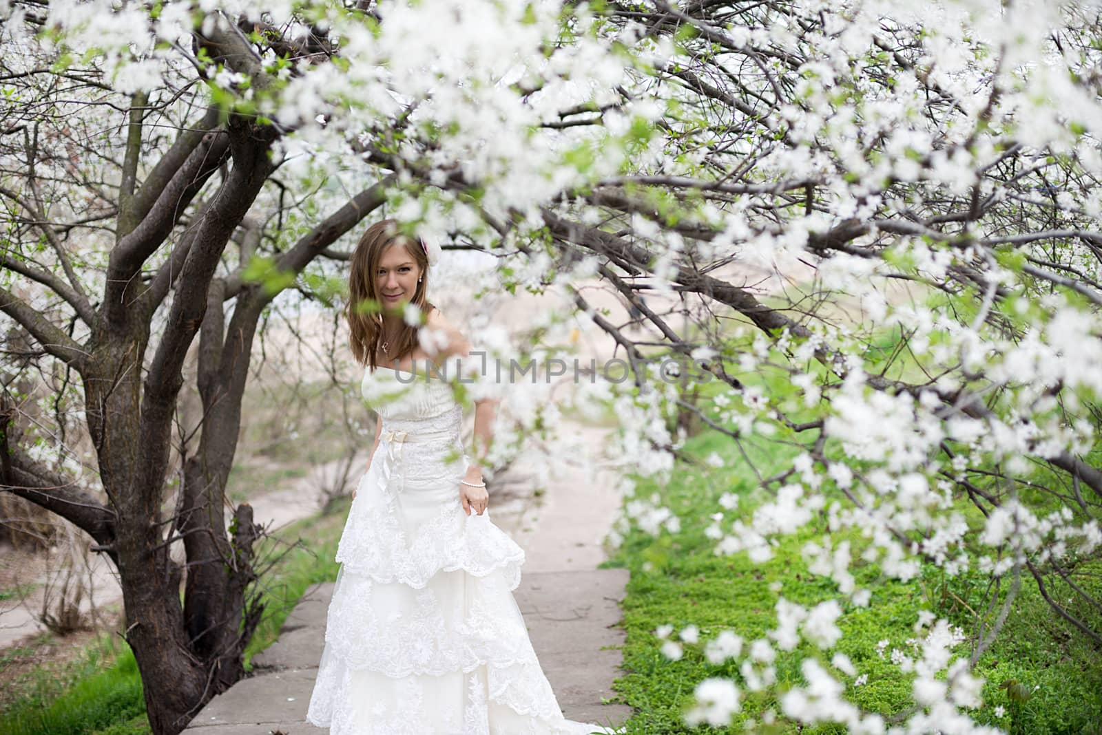 Portrait of beautiful blond bride in spring blossom
