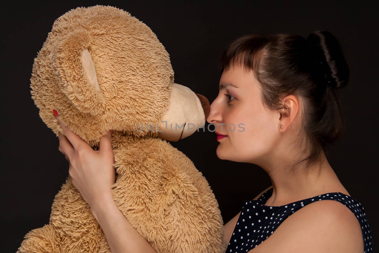 portrait of a stylish expressive woman with teddy bear in studio