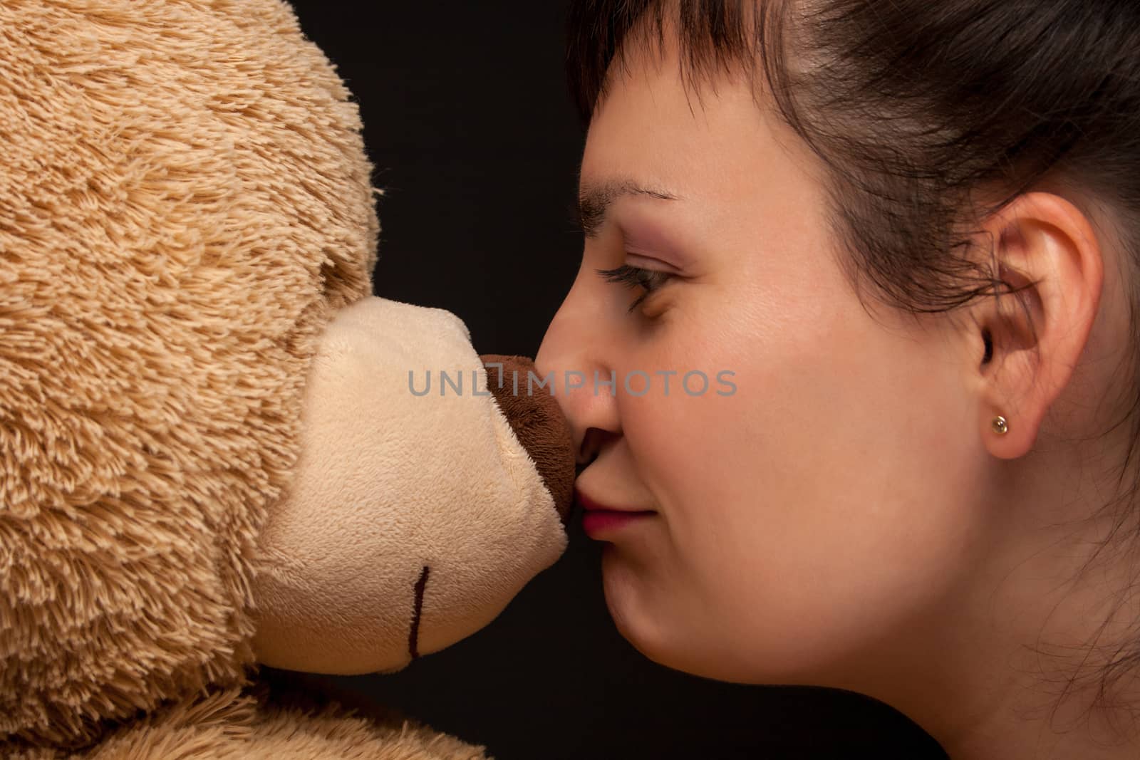 portrait of a stylish expressive woman with teddy bear in studio