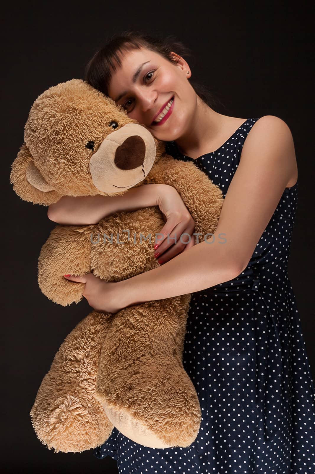 portrait of a stylish expressive woman with teddy bear in studio