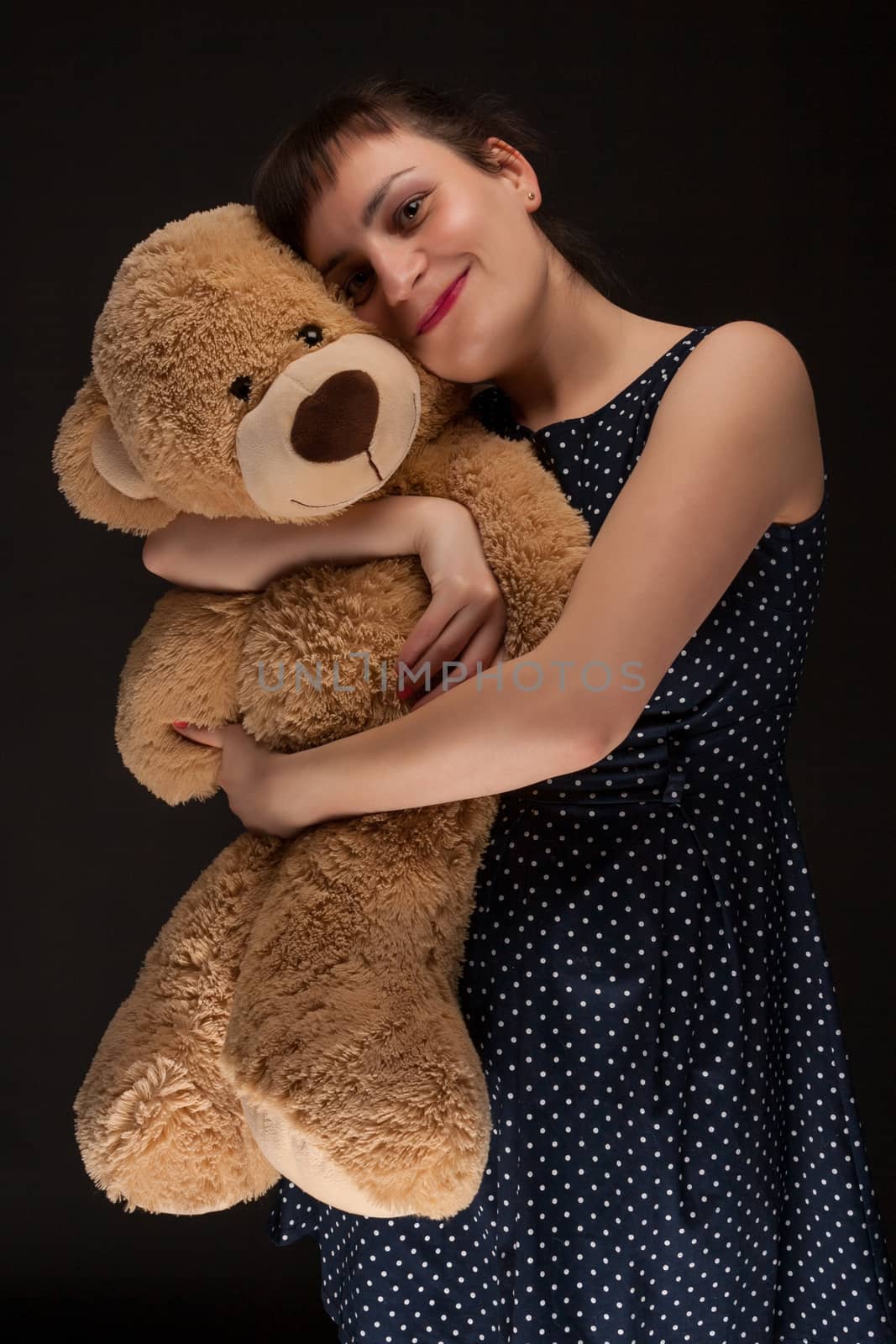 portrait of a stylish expressive woman with teddy bear in studio