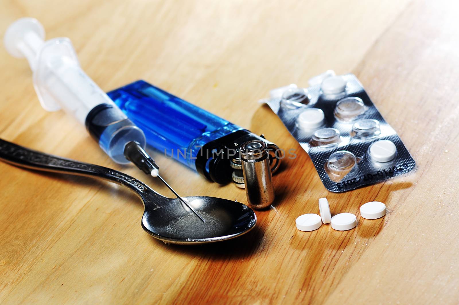 syringe, spoon ,pills,bullet and lighter on the floor