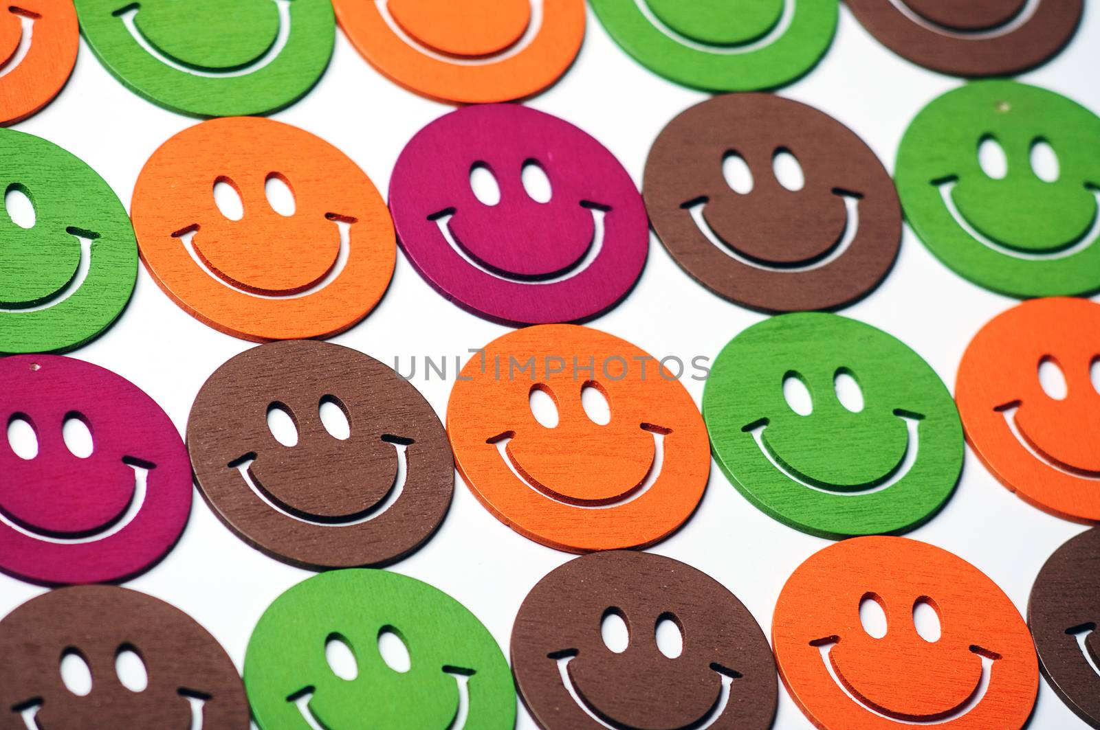 smiling wooden multi colored emoticons in row