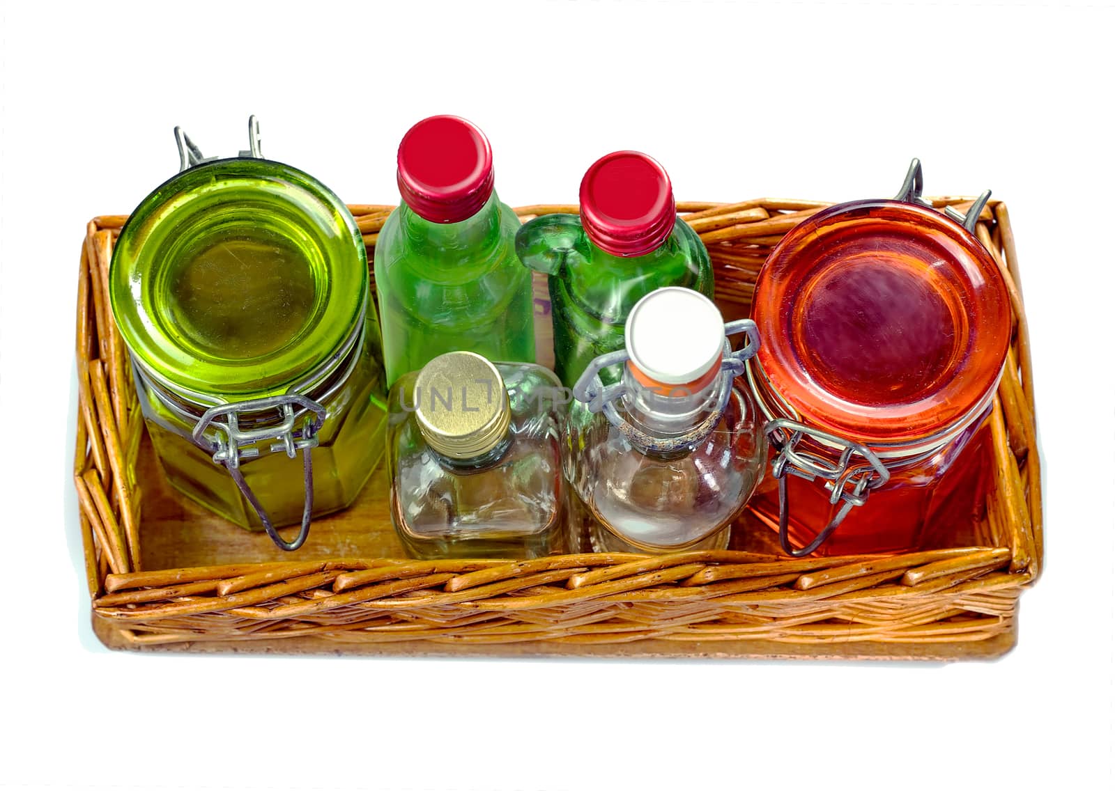 Wicker tray with empty glass jars and little glass bottle, isolated on white background