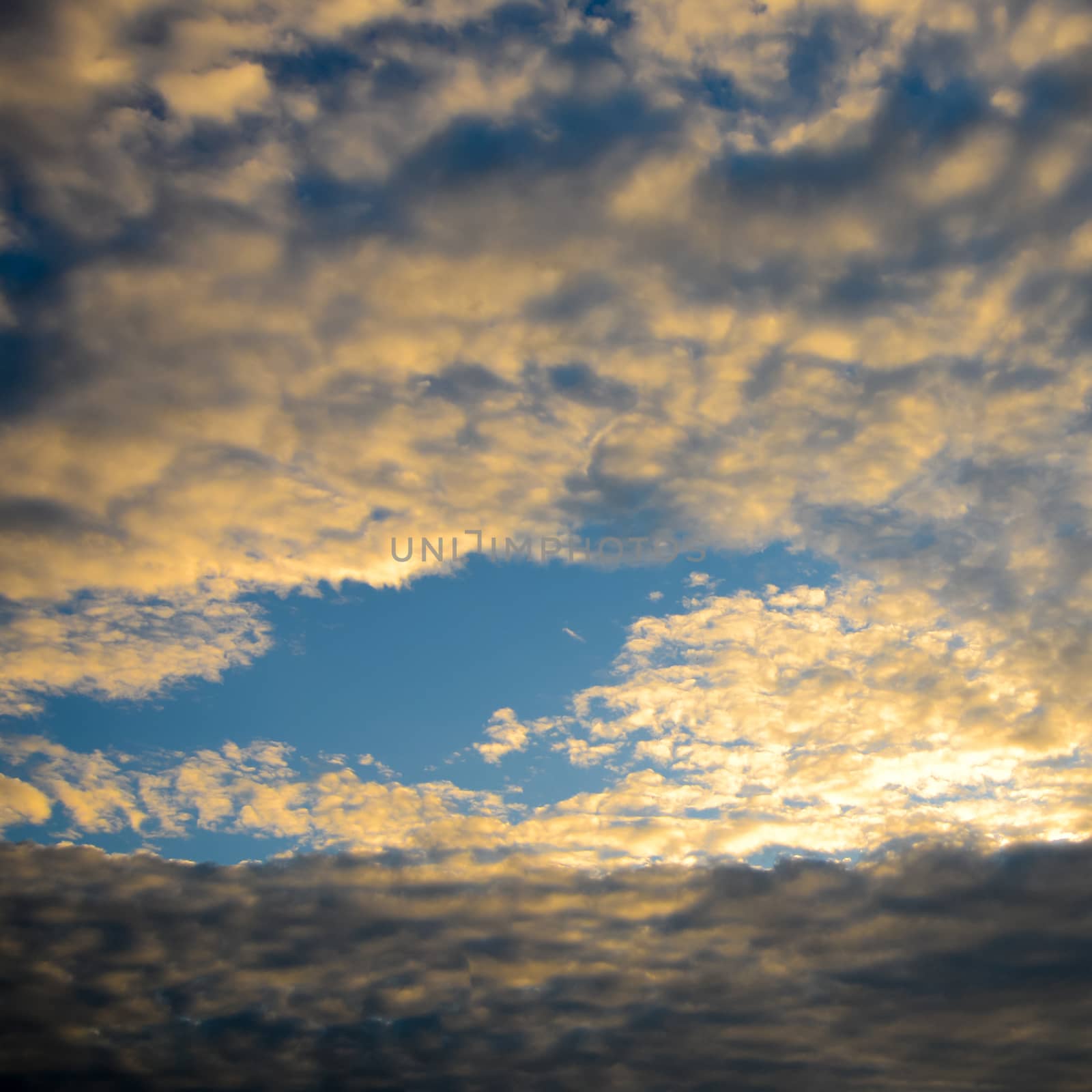 The blue sky and white fluffy clouds .