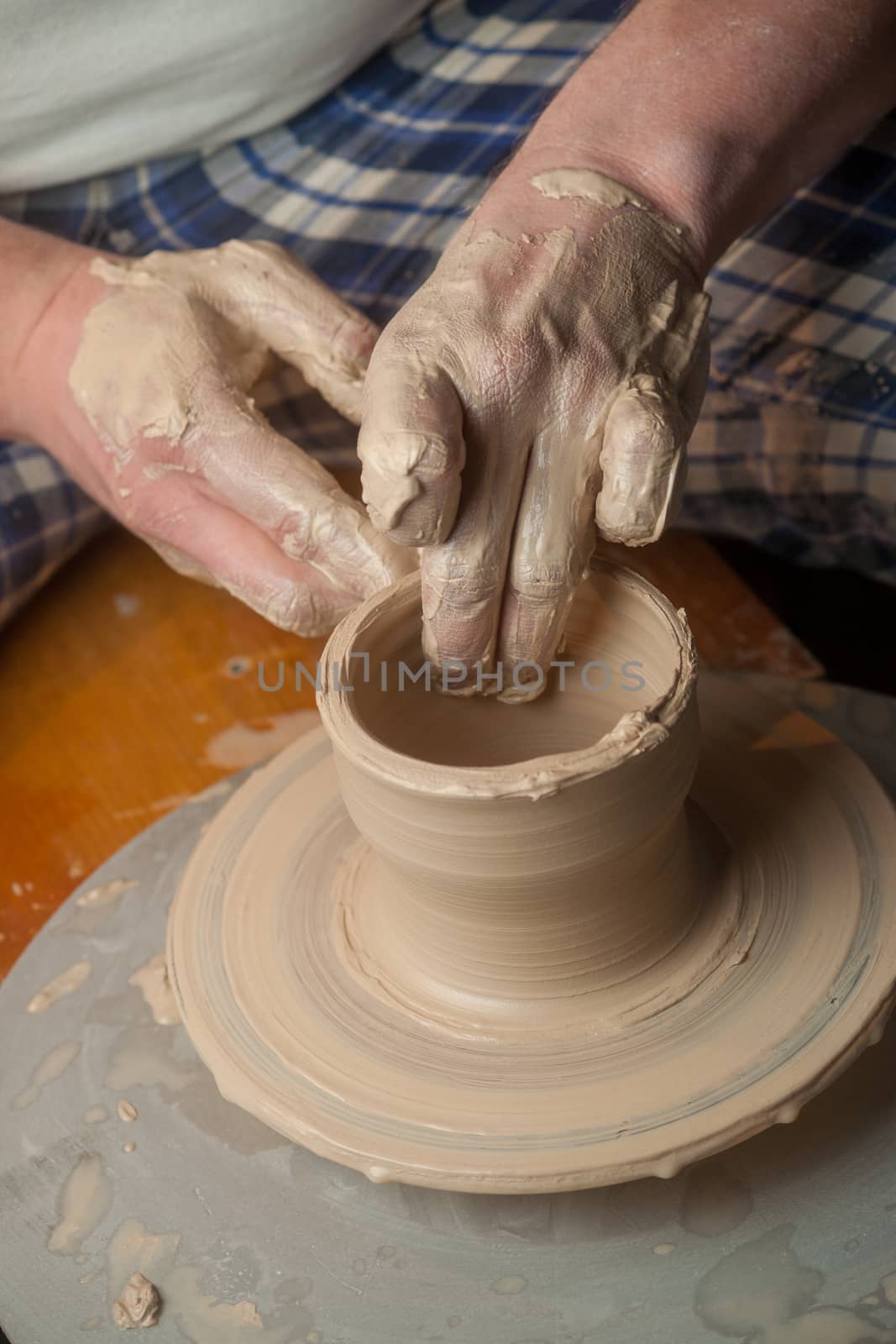 Hands of a potter, creating an earthen jar on the circle