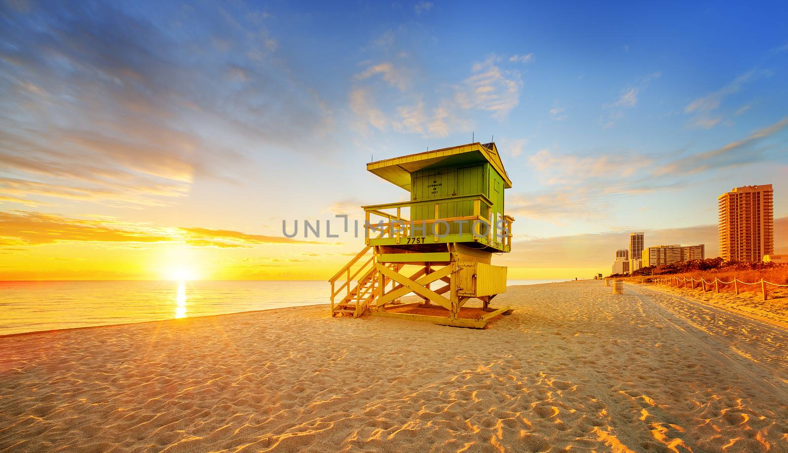 Miami South Beach sunrise with lifeguard tower and coastline with colorful cloud and blue sky. 