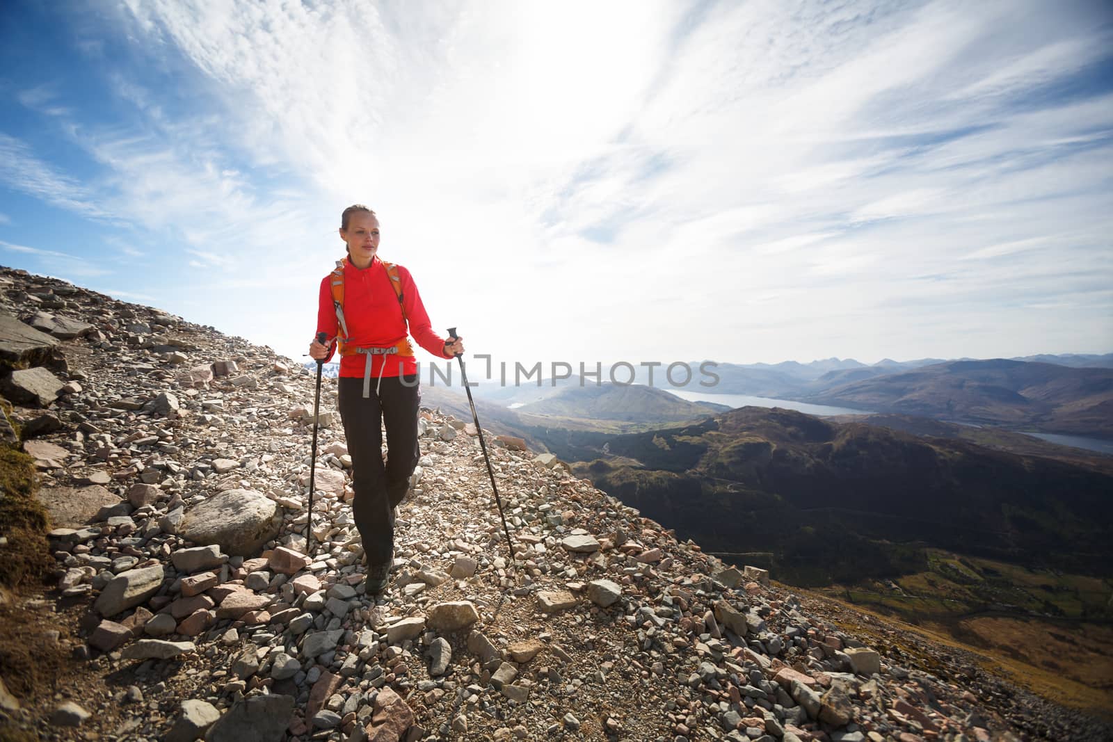 Pretty, young female hiker going uphill