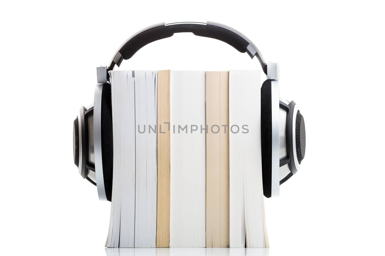 Audiobook concept - listen to your books in HD quality; hi-end hifi headphones over multiple books on white