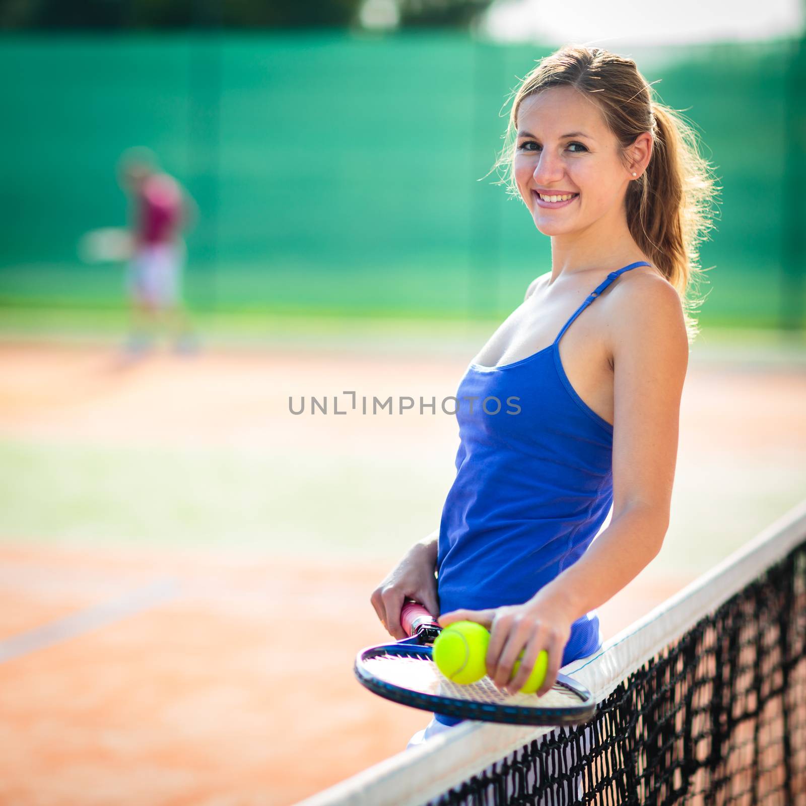 Portrait of a pretty, young tennis player  on  a court on a lovely summer day