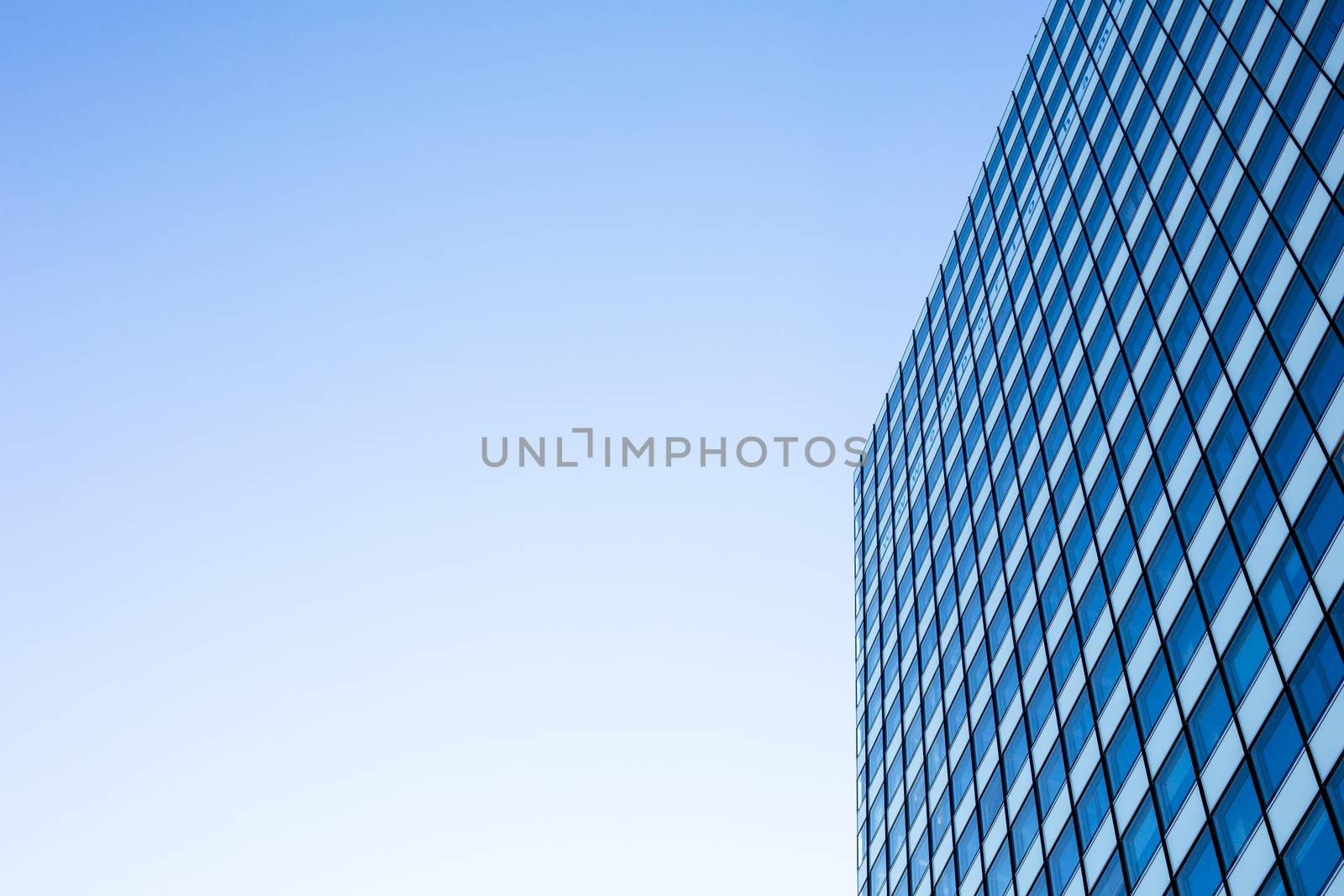 Exterior of building - abstract concept; skyscraper from down below against blue sky