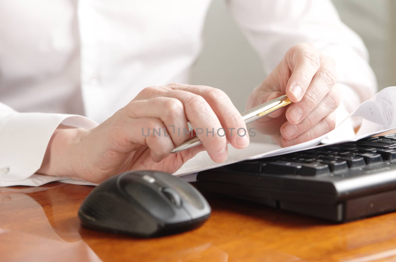 Hands with a document on a computer keyboard