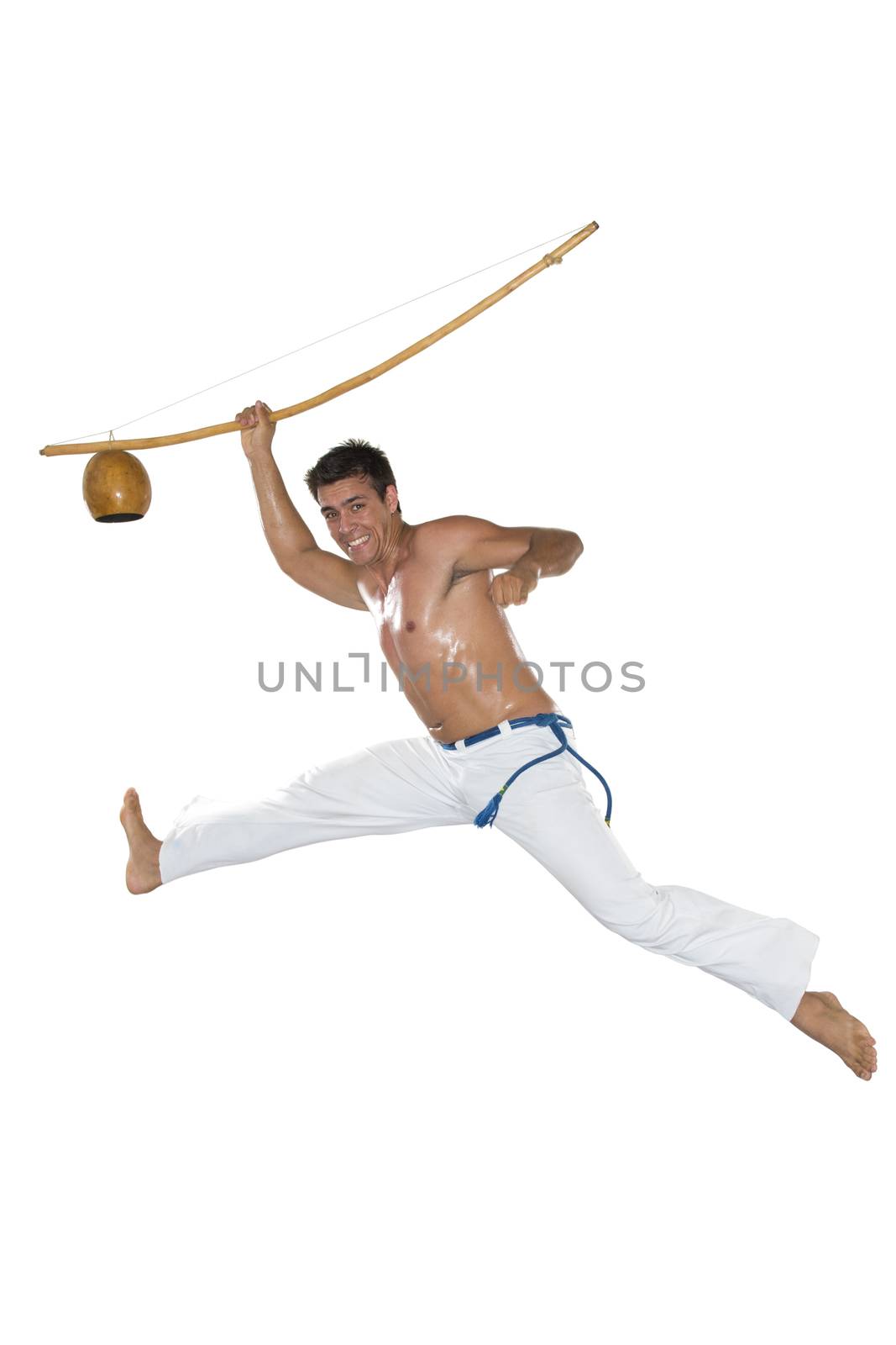 Capoeira, Brazilian Man jumping, holding a berimbau.