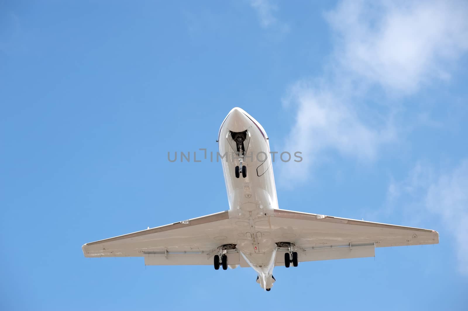 business jet on landing approach against a blue sky