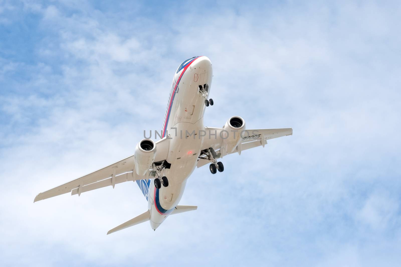 Farnborough, UK - July 20, 2010: Russian developed Sukhoi Superjet 100-95 with undercarriage down on landing approach to Farnborough Airshow, UK