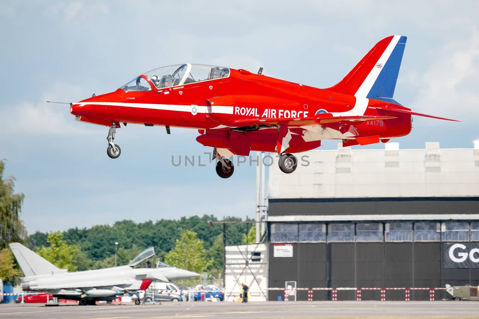 Farnborough, UK - July 25, 2010: Close-up of a Red Arrows display jet landing with a Eurofighter in the background at the Farnborough Airshow, UK