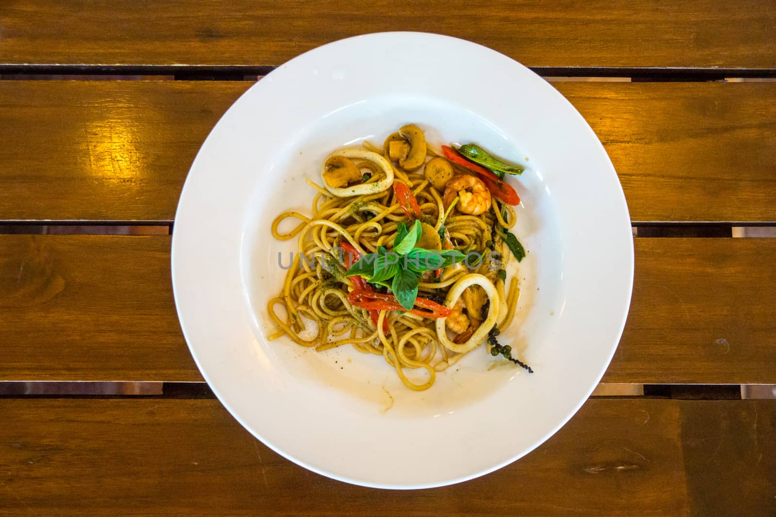 one dish of hot and spicy seafood spaghetti on wooden table,shallow focus