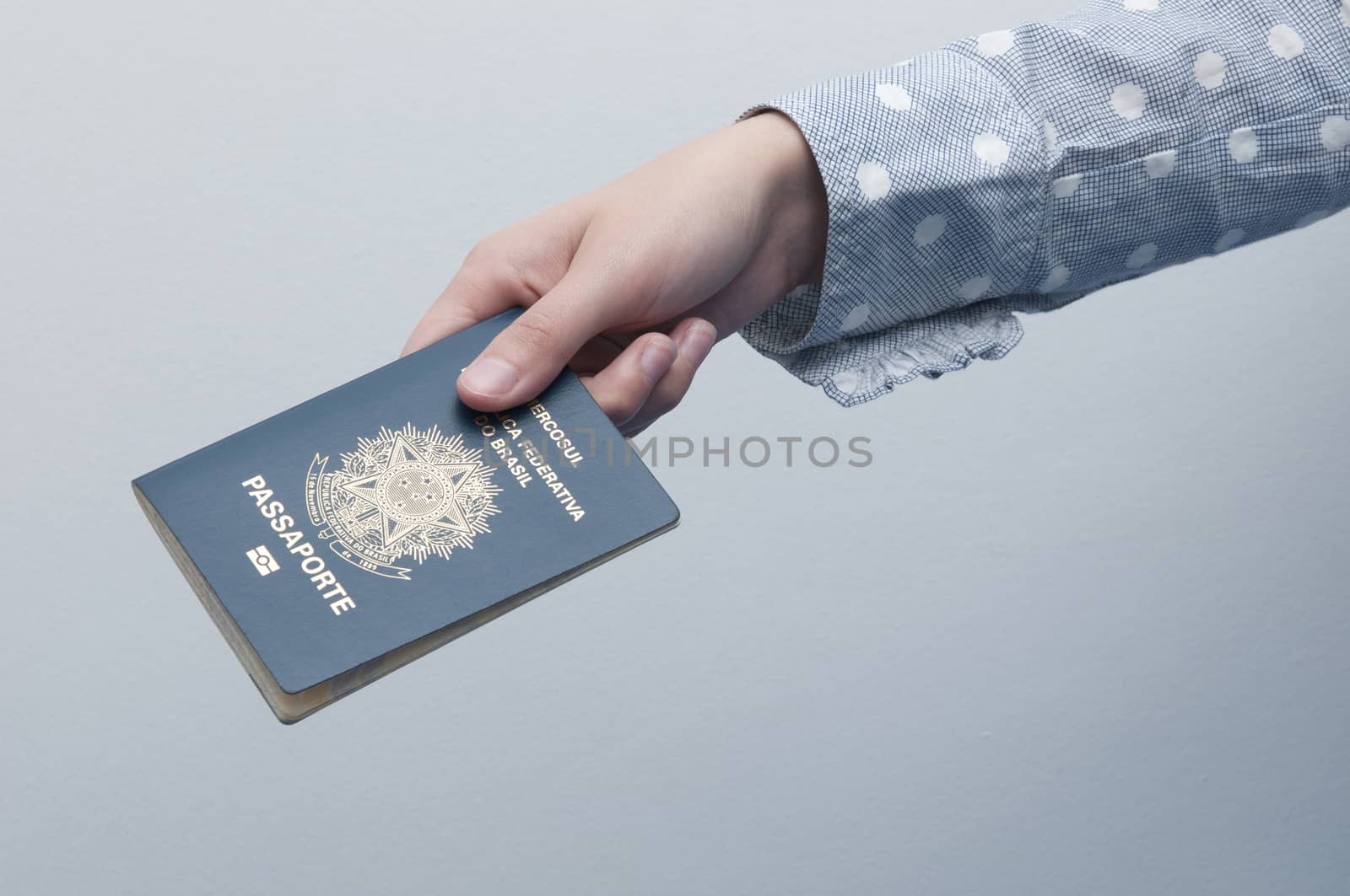Caucasian Woman holding a brazilian passport / A passport is a government-issued document that certifies the identity and nationality of its holder for the purpose of international travel.