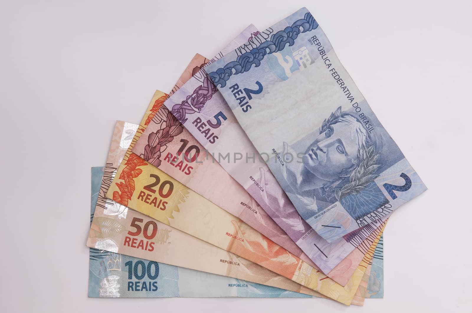 A few bills of brazilian currency (real) on white background