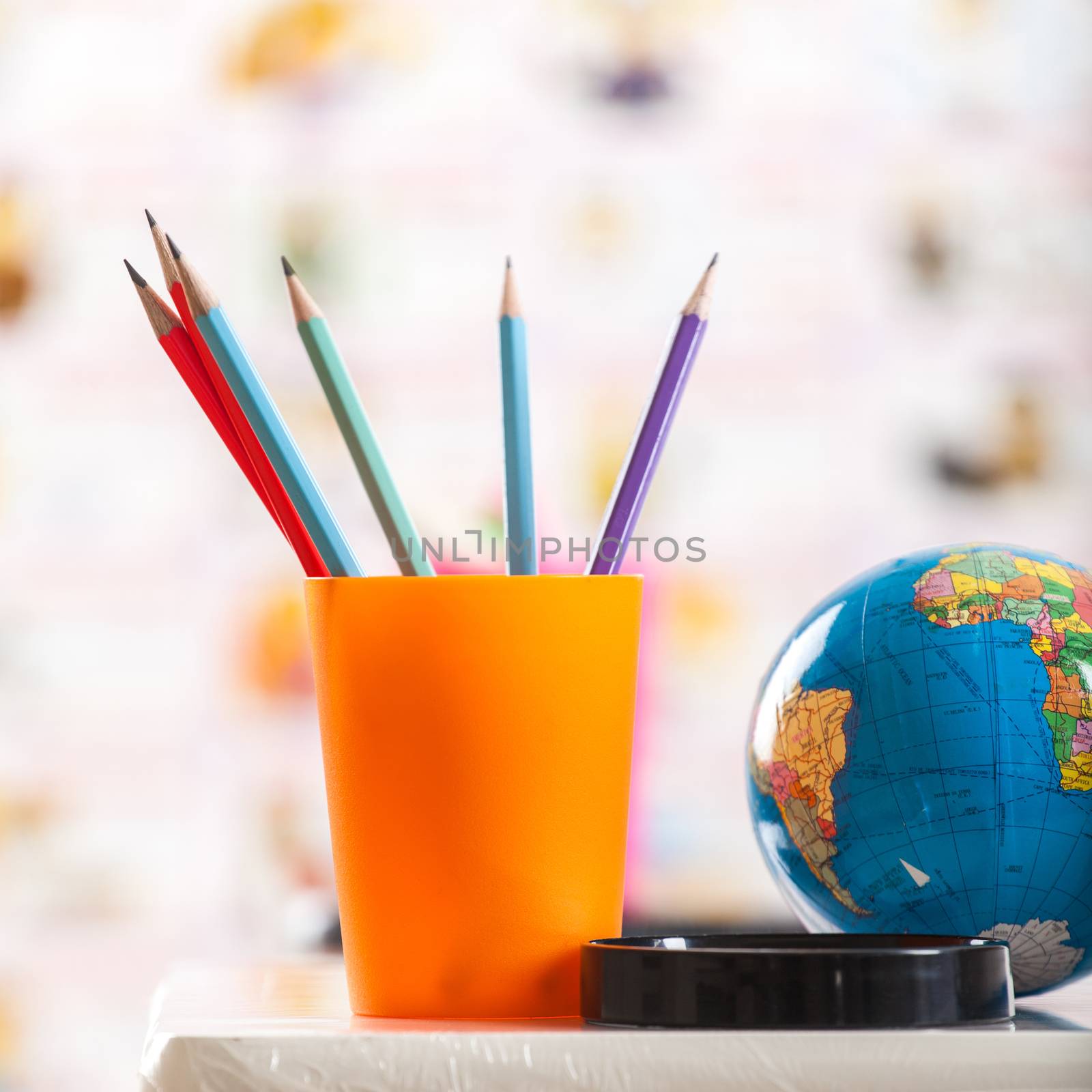 Pencils, globe and book on table 