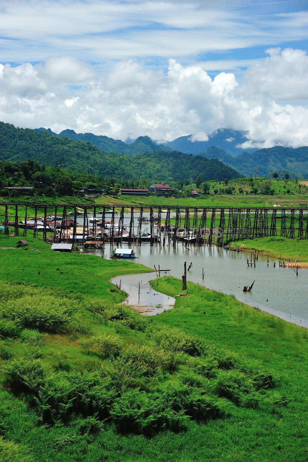 Wood bridge with river and mountain in Kanchanaburi Thailand by think4photop
