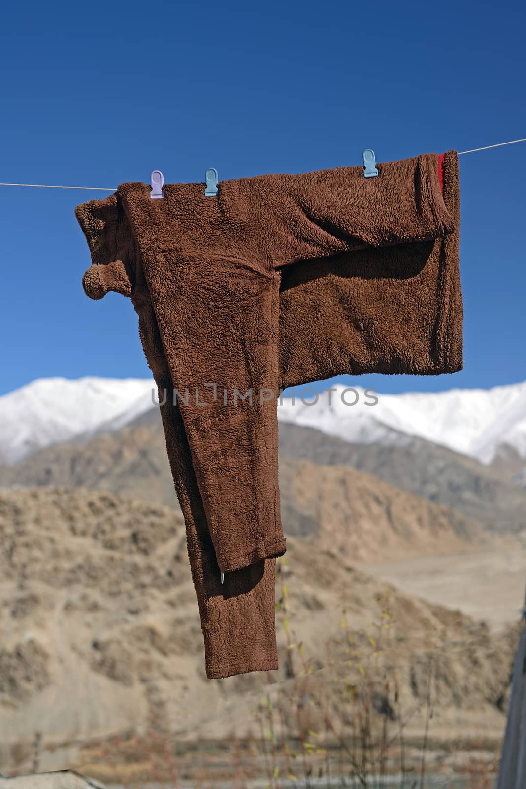 snow coats hanging to dry on wire in snow mountain background