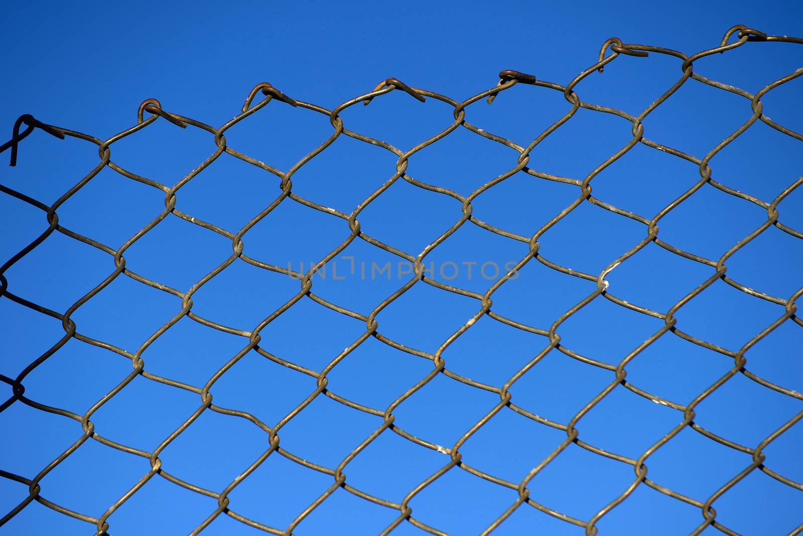 Steel net fence with blue sky background.